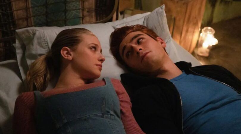 Jongen en meisje liggen op bed en kijken elkaar aan.