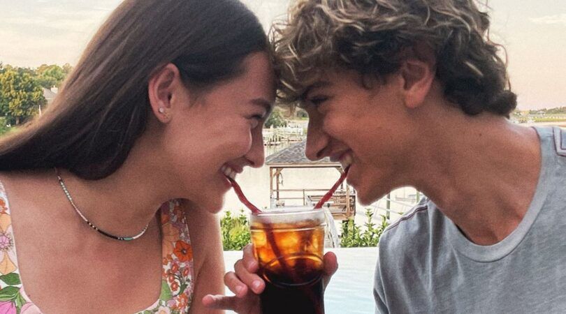 jongen en meisje drinken samen een cocktail uit &eacute;&eacute;n glas