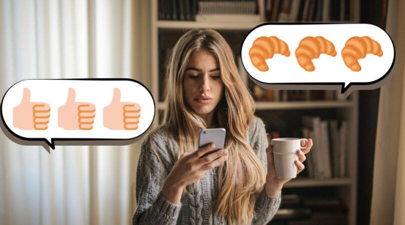 Vrouw kijkt op haar telefoon met een kopje koffie in haar hand.