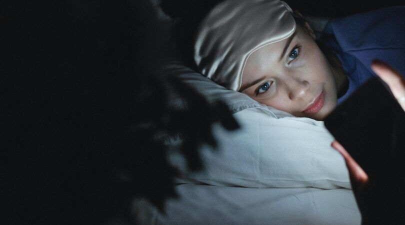 meisje in het donker op haar telefoon