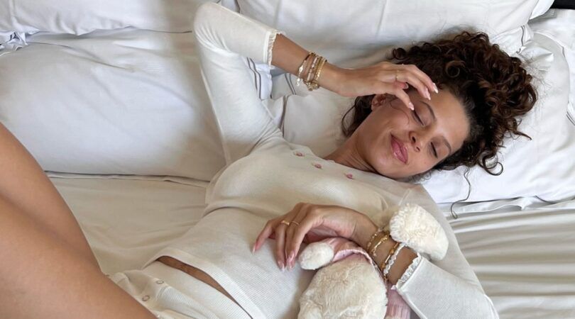 Zara Goedemans die in bed ligt met een knuffel in haar armen.