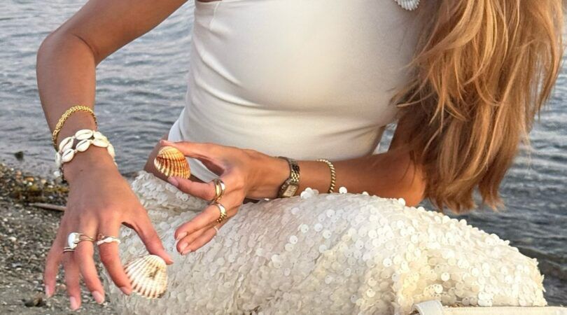 Een vrouw die schelpen aan het verzamelen is.