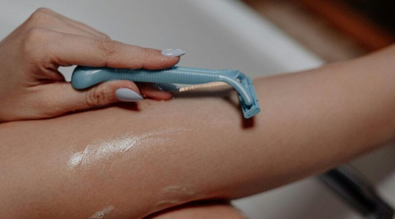 Vrouw scheert been in bad.