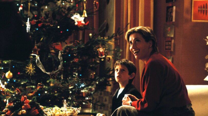 Een moeder en zoon zitten voor de kerstboom in love actually