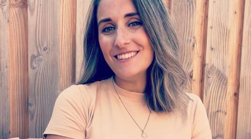 Vrouw kijkt lachend in de camera.