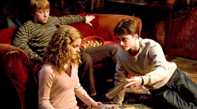 Hermione, Ron en Harry bladeren samen door nieuwsartikelen.