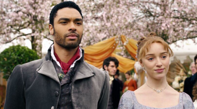 Twee personages uit Bridgerton staande voor een achtergrond.