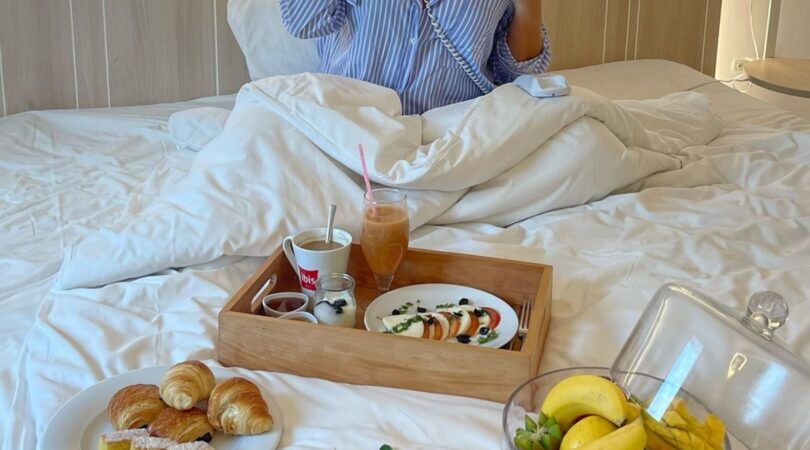 Iemand die ontbijt op bed eet