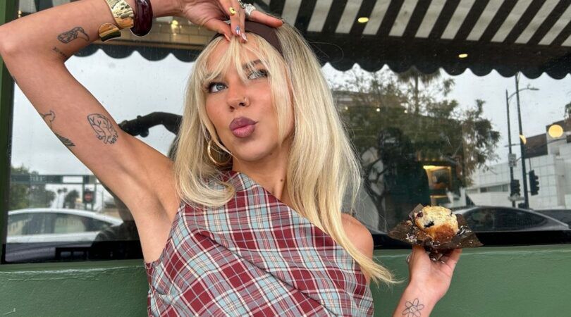 Een jonge vrouw lacht naar de camera.