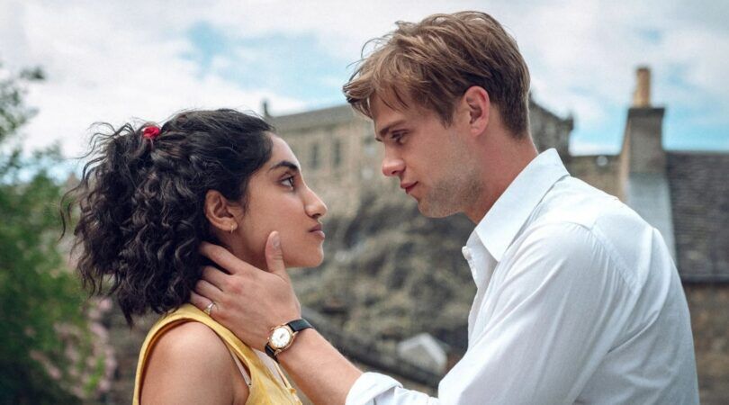 Man houdt het gezicht van een vrouw lief vast. Ze kijken heel verliefd naar elkaar.