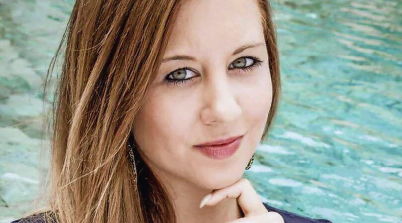 Deborah Leemans van Temptation Island zit bij een zwembad. Ze houdt haar kin met haar wijsvinger vast.