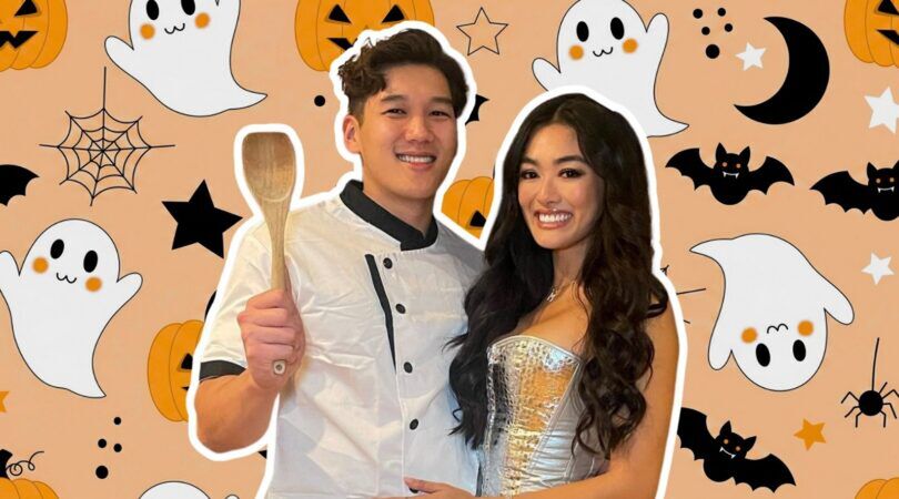 Koppel staat in Halloween kostuum voor een drukke Halloween achtergrond.