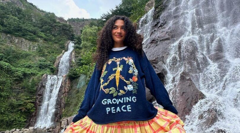 Olivia Dean poseert voor een foto voor een waterval.