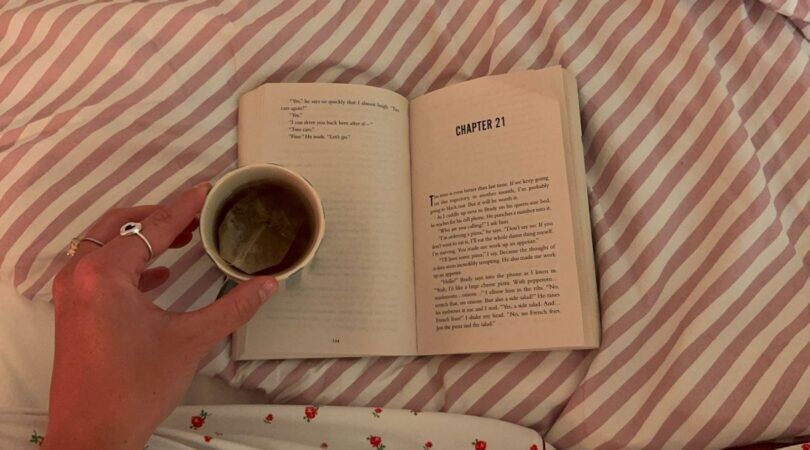 Een meisje met haar boek en een kopje thee.