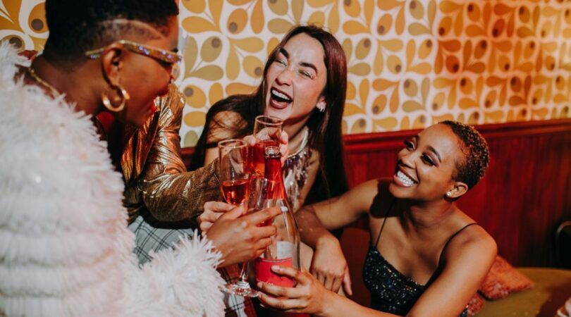 Drie vriendinnen proosten tijdens de feestdagen.