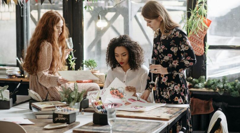 Drie vrouwen zijn bezig met een Sip & Paint-workshop bezig.