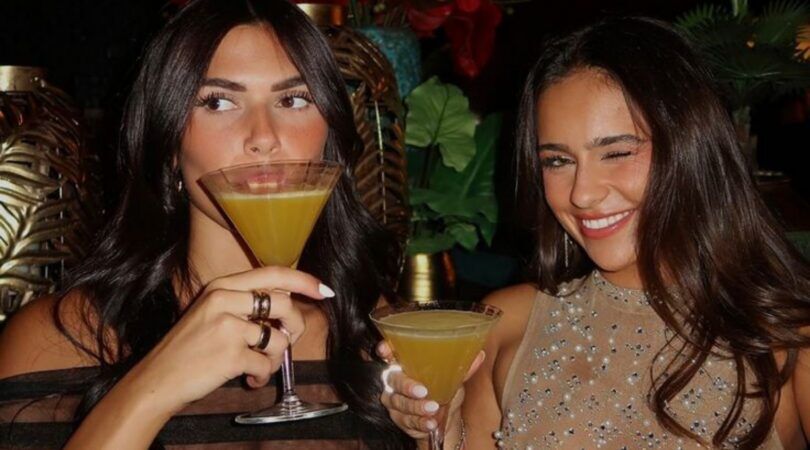 Twee vrouwen proosten met hun cocktailglazen.