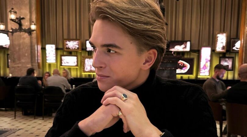 Foto van de zanger Antoon. Hij zit aan tafel en kijkt naar de zijkant. Hij houdt zijn handen gevouwen onder zijn kin.