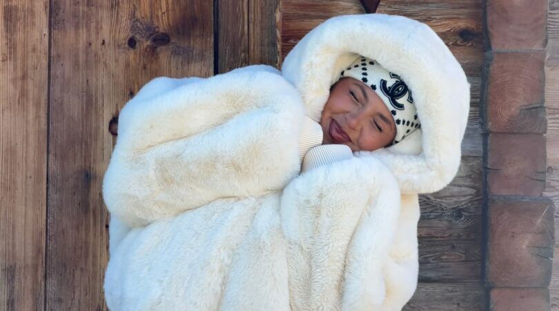 Een meisje in een dikke witte fur jacket.