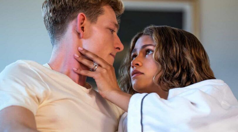 Filmstill uit de film: Challengers. Zendaya grijpt naar de wang van tegenspeler Mike Faist. Ze kijkt hem indringend aan.