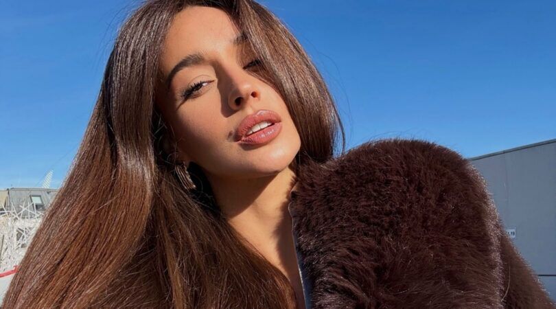 Een vrouw met mooi dik haar poseert voor een selfie.