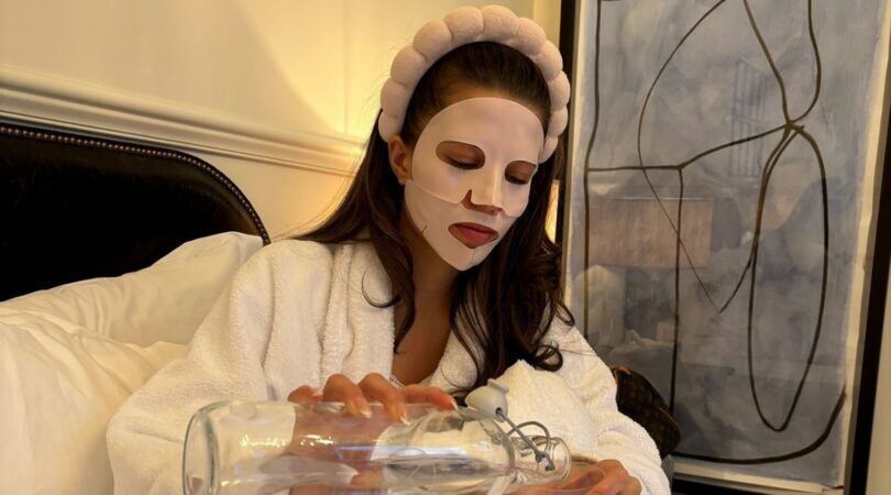 Zara Goedemans zit op bed met een gezichtsmaskertje op.