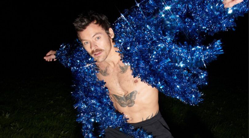 Harry Styles in een blauwe glitter jas.