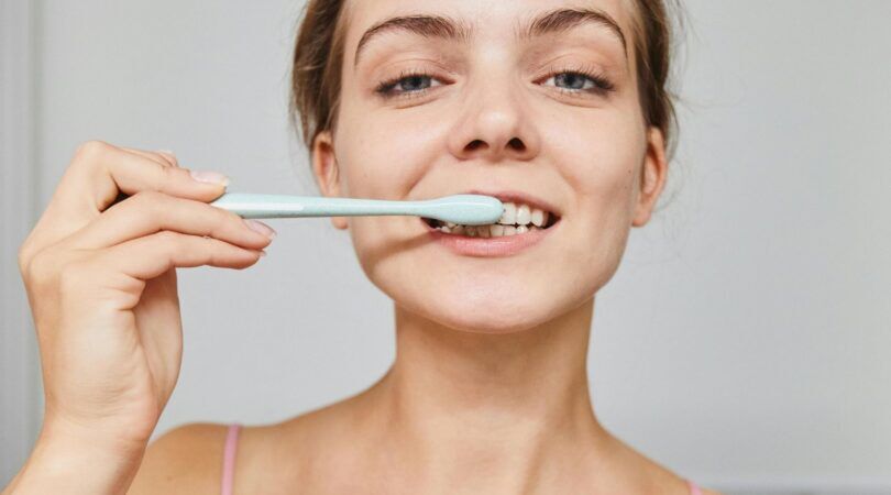 Jonge vrouw poetst haar tanden.