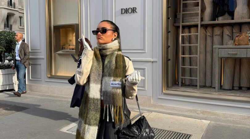 Een jonge vrouw met een grote geblokte sjaal om.