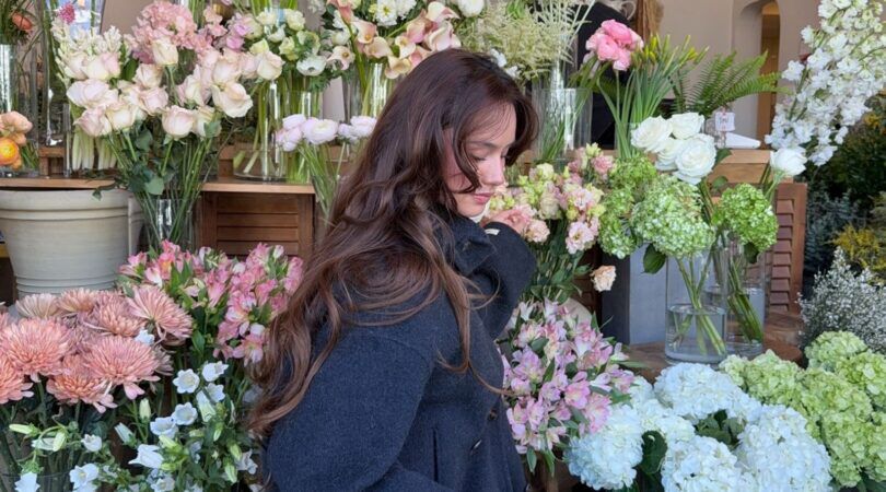 Meisje met bloemen op de achtergrond.