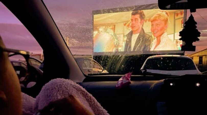 Foto van een drive-in bioscoop bij zonsondergang.