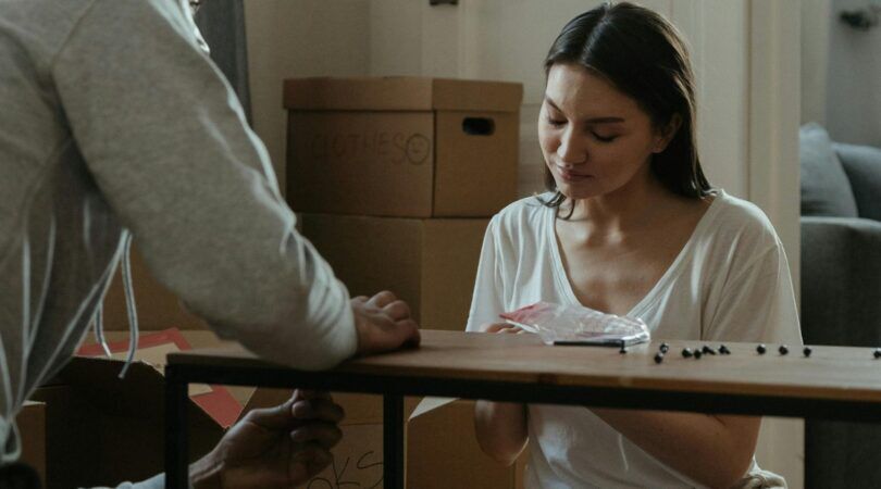 Een vrouw zet een tafel in elkaar.