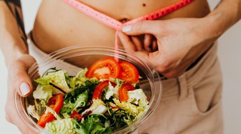 Een vrouw die een salade vast heeft.