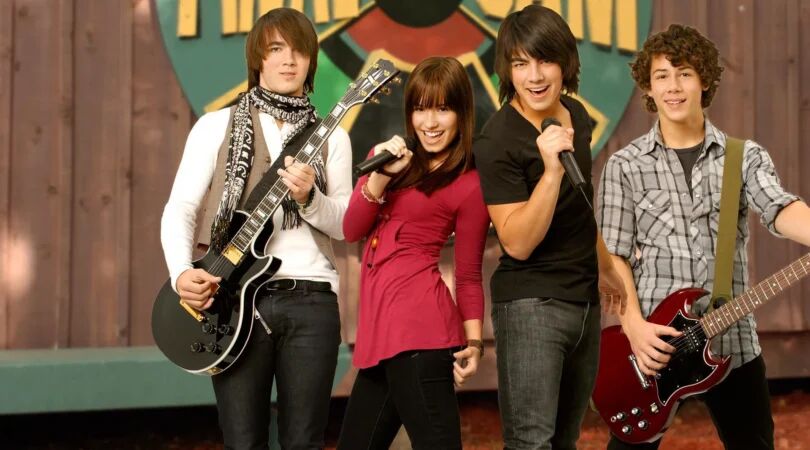 Demi Lovato, Kevin, Joe en Nicky Jonas met muziekinstrumenten