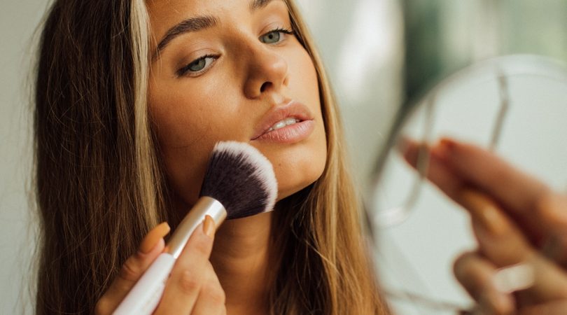 Vrouw brengt bronzer aan.