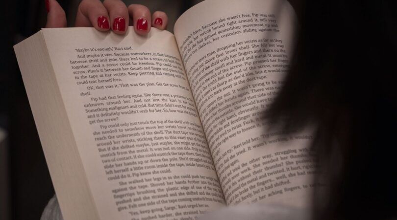 Vrouw leest uit een boek.