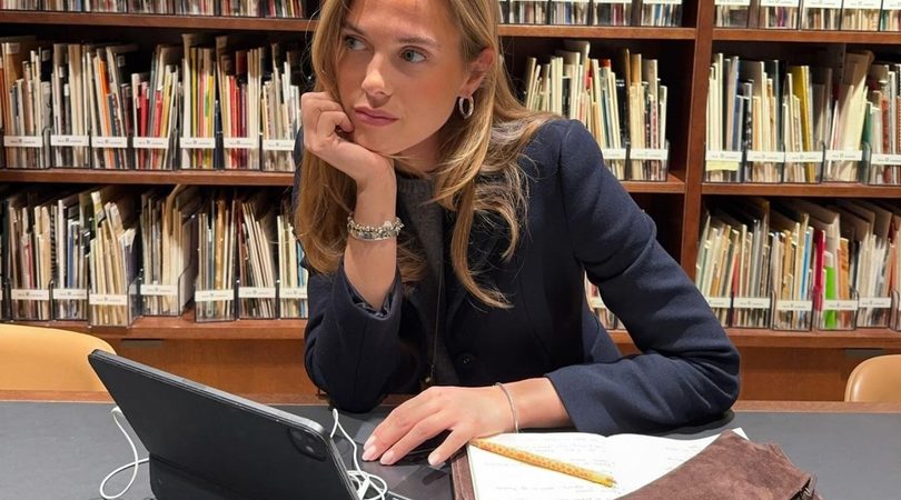 Meisje zit verveeld in een bibliotheek te werken.