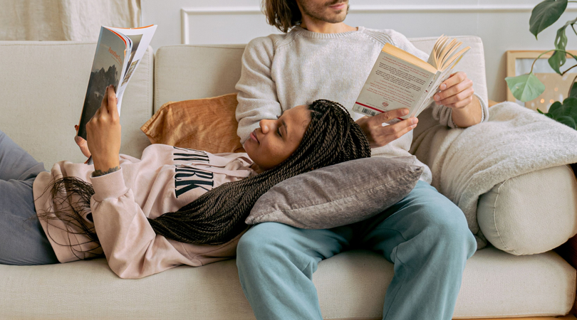 Koppel leest ieder een eigen boek cozy op de bank
