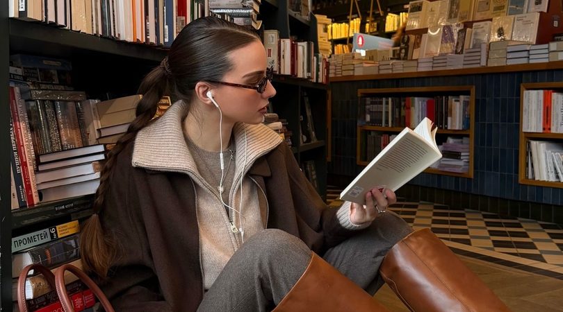 Meijse leest een boek in een bibliotheek