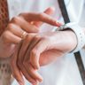 Vrouw kijkt op horloge.