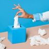 Een hand die een tissue pakt.