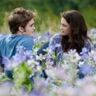Bella en Edward in een veld vol bloemen.