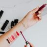 Een vrouw met verschillende kleuren lippenstift op haar arm uitgeprobeerd.