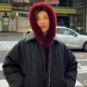 Lily Muni He poseert vooor een foto. Ze draagt een dikke winterjas