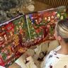 Vrouw opent adventskalender voor haar kerstboom.