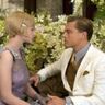 Gatsby en Daisy kijken elkaar aan en om hun heen zitten veel bloemen.