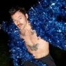 Harry Styles in een blauwe glitter jas.