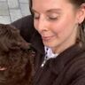 Vrouw die haar hond knuffelt.