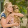 Moeder en dochter uit Mamma Mia! geven elkaar een knuffel.