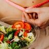 Een vrouw die een salade vast heeft.